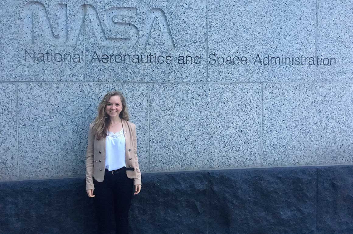student in front of sign for NASA